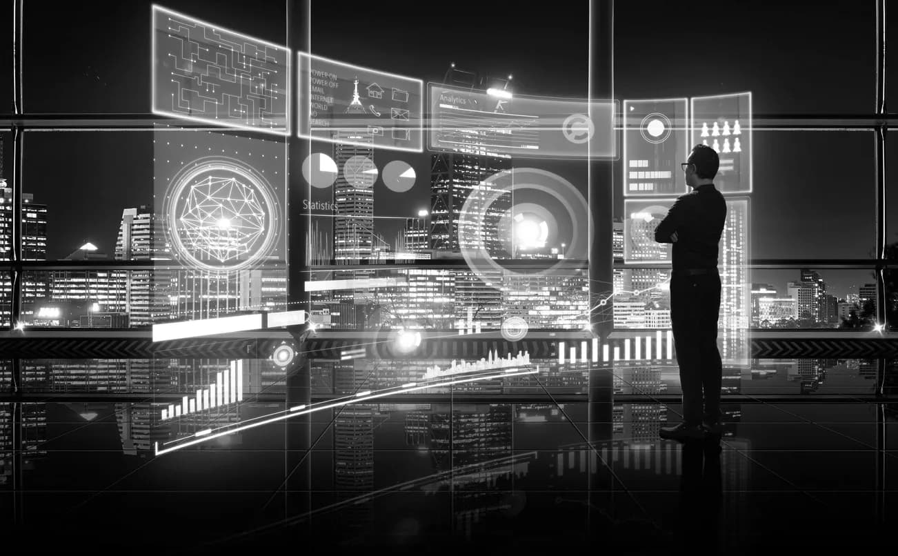 Businessman studying data dashboards over a night city skyline